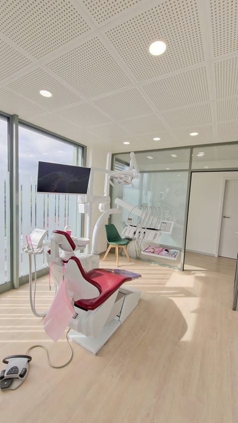 Salle de soins lumineuse avec fauteuil dentaire et grande baie vitrée