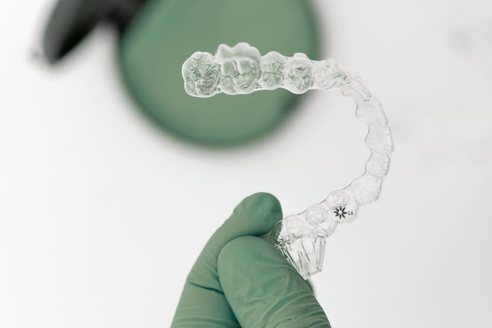 Gouttière transparente de blanchiment tenue par une main gantée